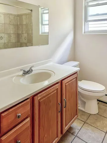a bathroom with a sink a toilet and a mirror