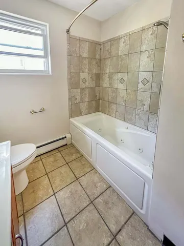a bathroom with a bathtub and a window