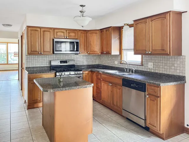 a kitchen with stainless steel appliances granite countertop a sink stove and cabinets