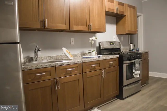 a kitchen with stainless steel appliances granite countertop a sink stove and cabinets