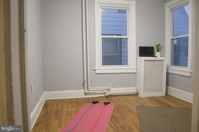a view of a room with wooden floor and a window