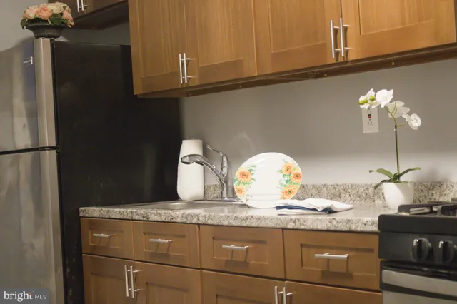 a kitchen with granite countertop a sink a stove and cabinets