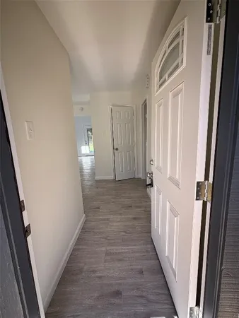 a view of a hallway with wooden floor