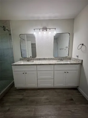 a bathroom with a granite countertop sink and a mirror