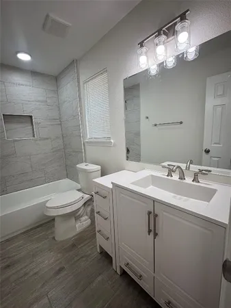 a bathroom with a double vanity sink mirror and toilet