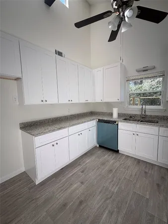 a kitchen with granite countertop white cabinets and white appliances