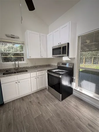 a kitchen with granite countertop a sink and steel appliances