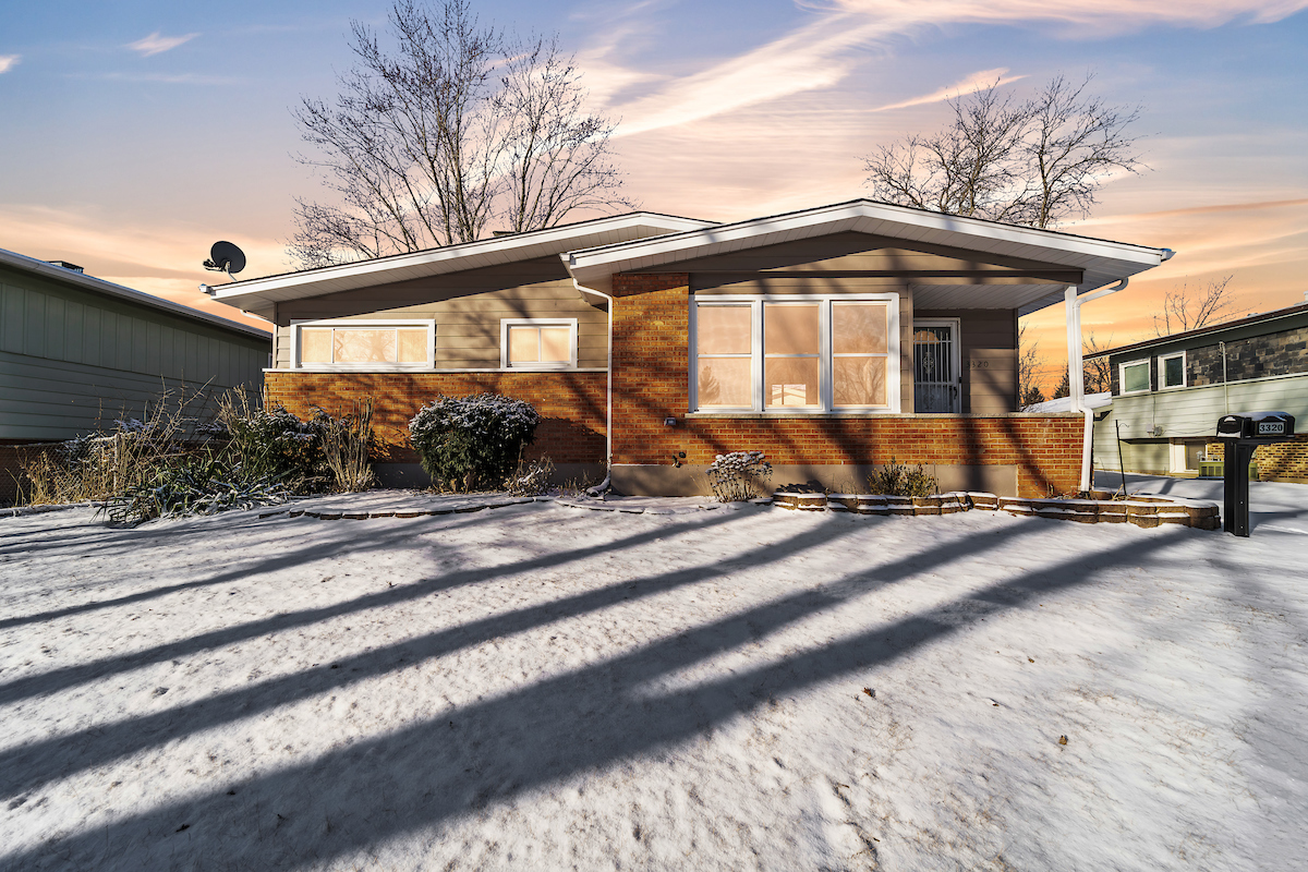 a front view of a house with a yard and seating space