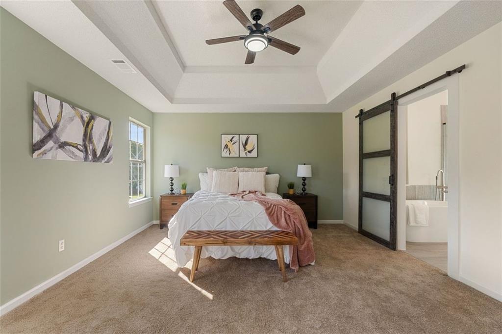 191 Kyndal Drive Hampton, GA 30228 - Photo 31 of 49 a spacious bedroom with a bed and a chandelier