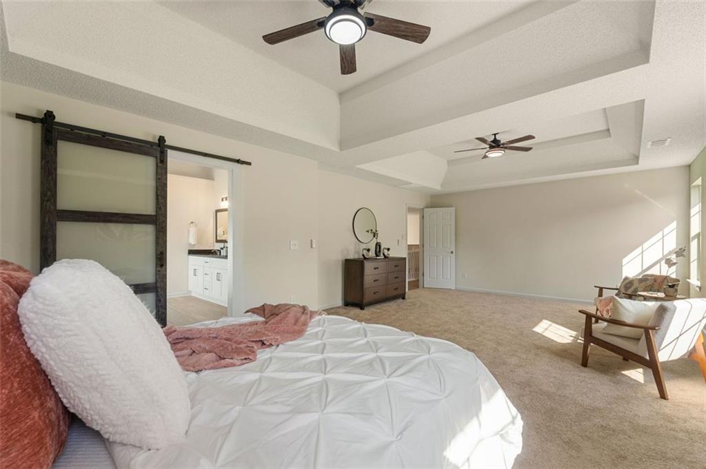 191 Kyndal Drive Hampton, GA 30228 - Photo 32 of 49 a bedroom with a bed and a chandelier