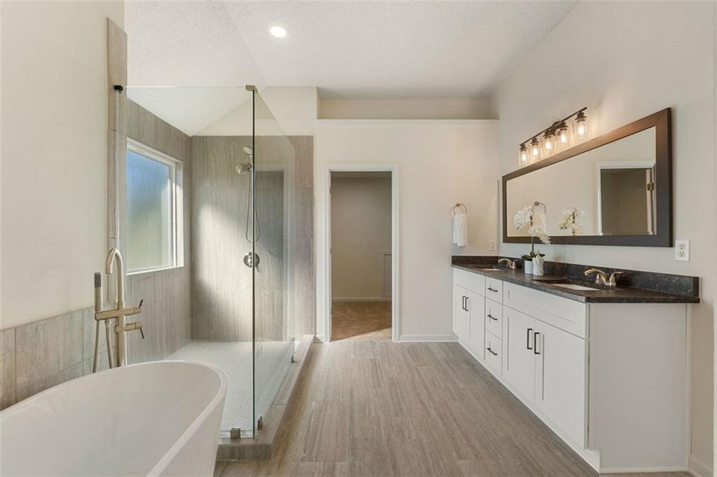 191 Kyndal Drive Hampton, GA 30228 - Photo 33 of 49 a bathroom with a granite countertop sink mirror and a bathtub