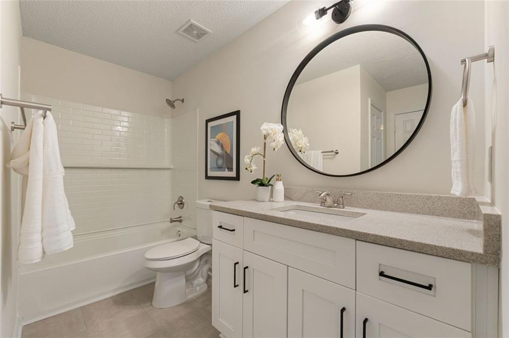 191 Kyndal Drive Hampton, GA 30228 - Photo 42 of 49 a bathroom with a granite countertop toilet a sink and a mirror