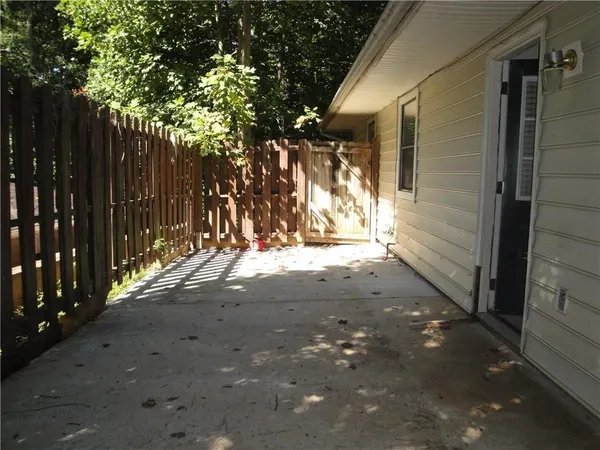 a view of backyard and wooden fence