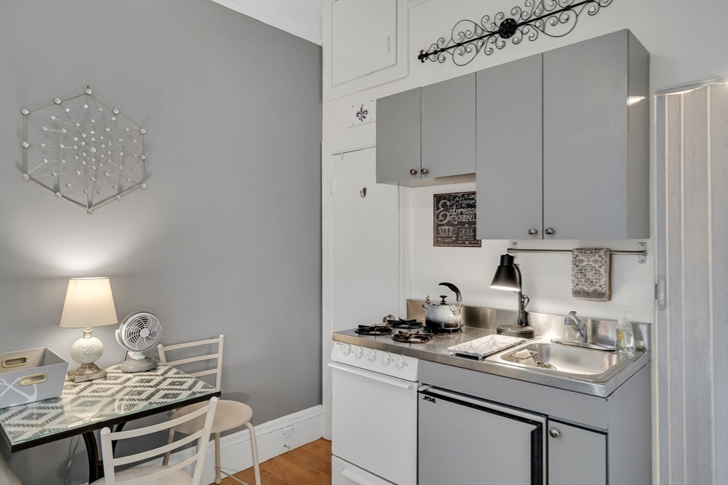 290 Commonwealth Avenue, Unit 8 Boston, MA 02115 - Photo 9 of 32 a kitchen with a sink cabinets and stove