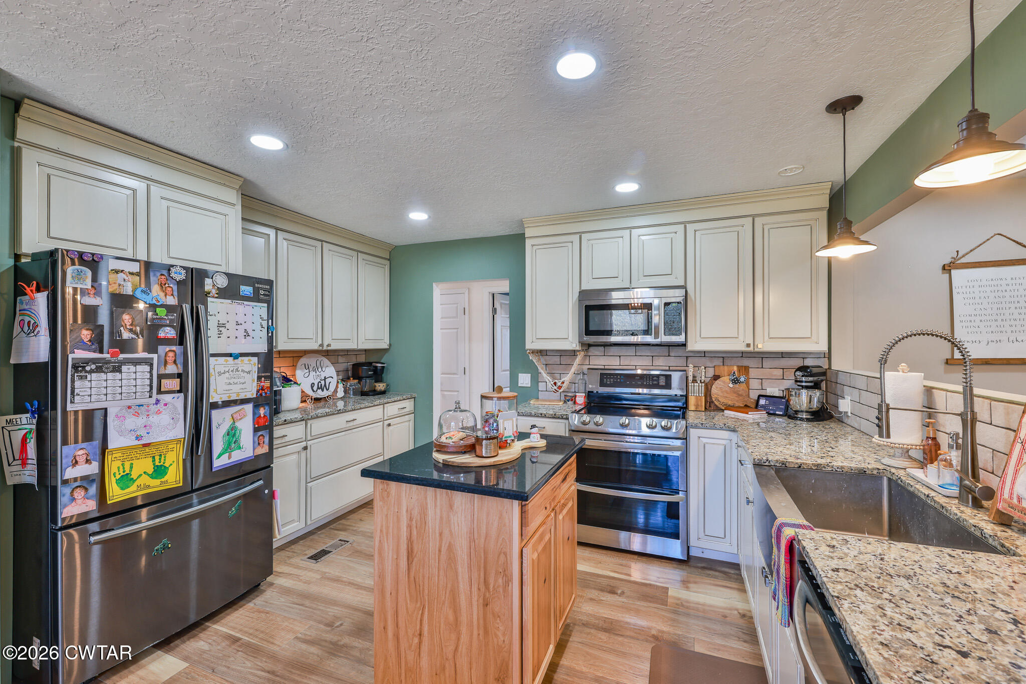 125 Old Dyer-Trenton Road Dyer, TN 38330 - Photo 6 of 40 a kitchen with stainless steel appliances granite countertop a stove top oven a sink dishwasher and cabinets with wooden floor