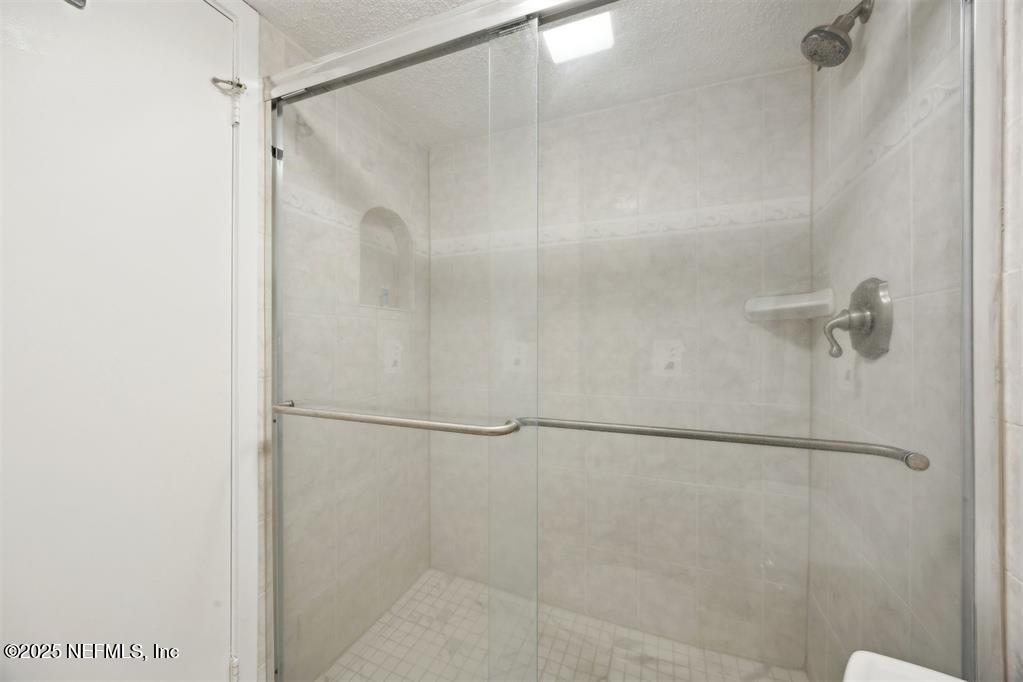 2021 Beachwood Road Fernandina Beach, FL 32034 - Photo 15 of 32 a bathroom with a glass shower door