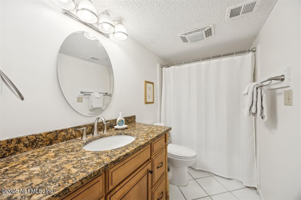 2021 Beachwood Road Fernandina Beach, FL 32034 - Photo 18 of 32 a bathroom with a granite countertop sink toilet and a mirror