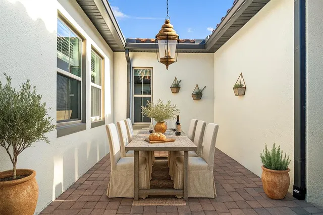 a living room with furniture kitchen view and a chandelier