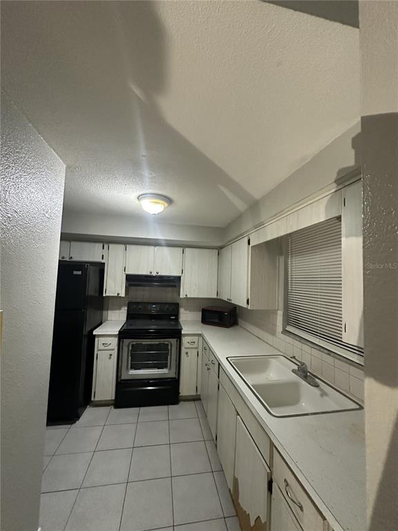 5509 Riddle Road Holiday, FL 34690 - Photo 5 of 13 a kitchen with a sink a stove and cabinets