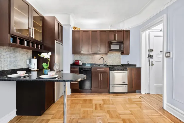 a kitchen with granite countertop stainless steel appliances and wooden cabinets