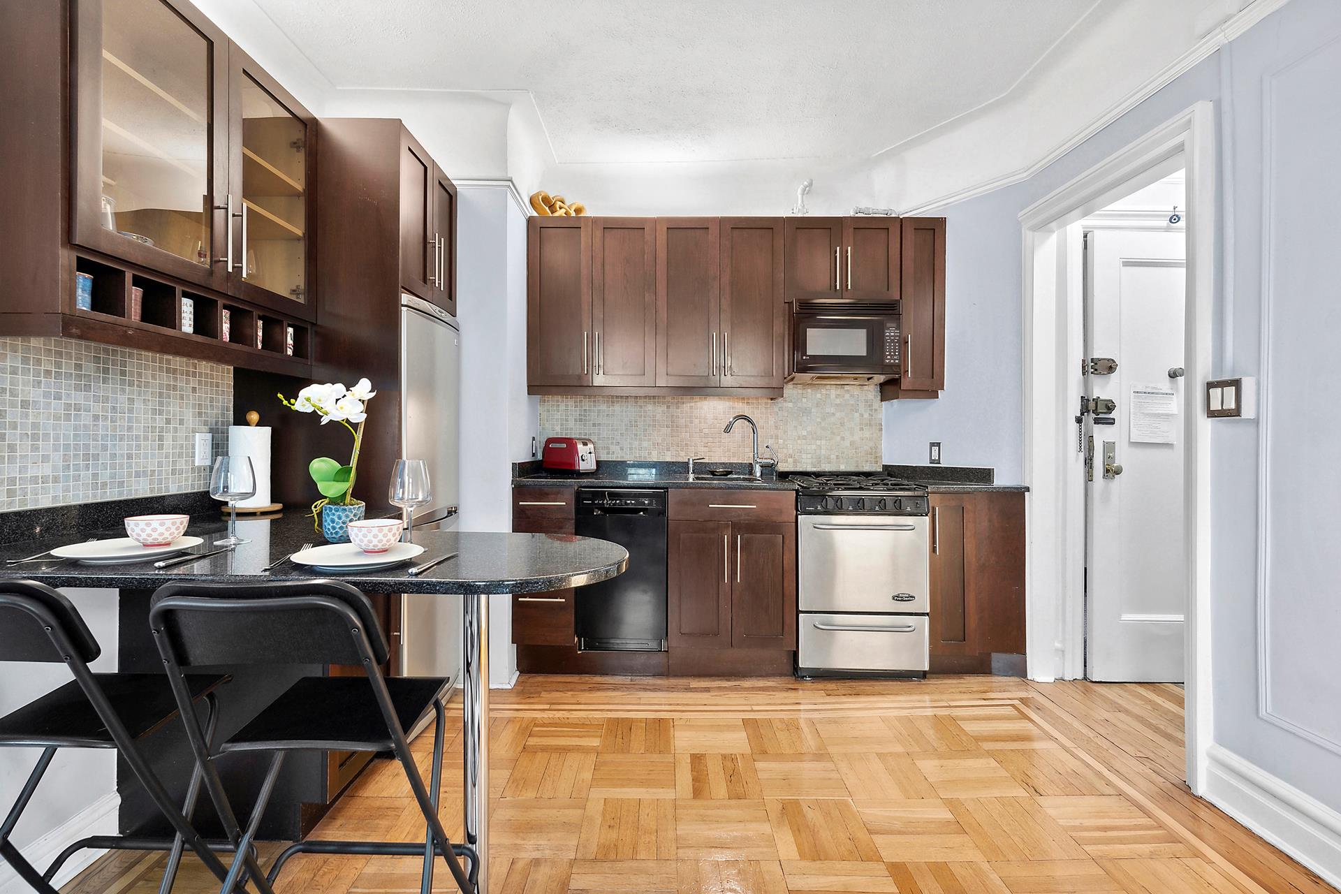 1-03 Minetta Street, Unit 5B Manhattan, NY 10012 - Photo 9 of 12 a kitchen with stainless steel appliances granite countertop a stove top oven a sink dishwasher and cabinets with wooden floor