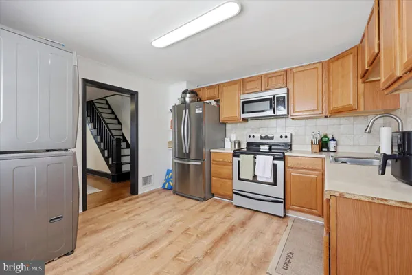 a kitchen with stainless steel appliances granite countertop a refrigerator stove and sink