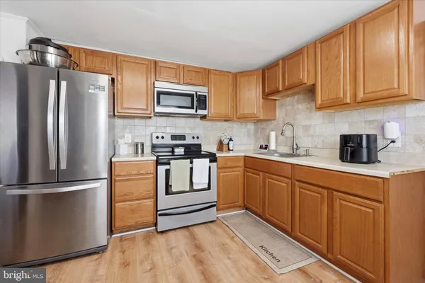 a kitchen with stainless steel appliances granite countertop a refrigerator sink and stove