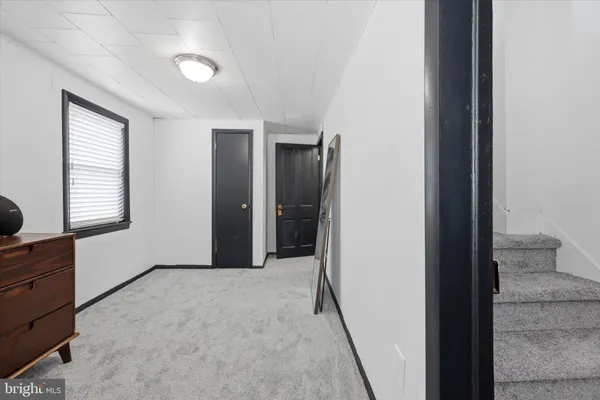 a view of hallway with a window and a dresser