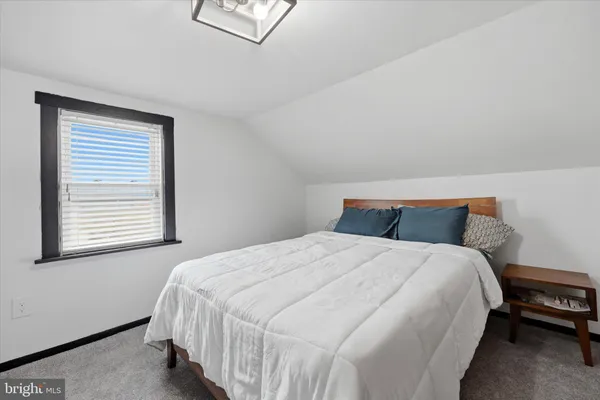 a large bed sitting in a bedroom next to a window
