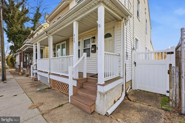 a view of a house with a small yard and wooden fence