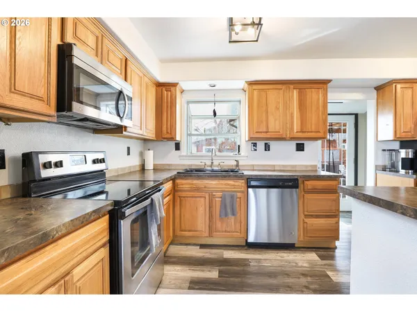 a kitchen with stainless steel appliances granite countertop a stove a sink and a microwave
