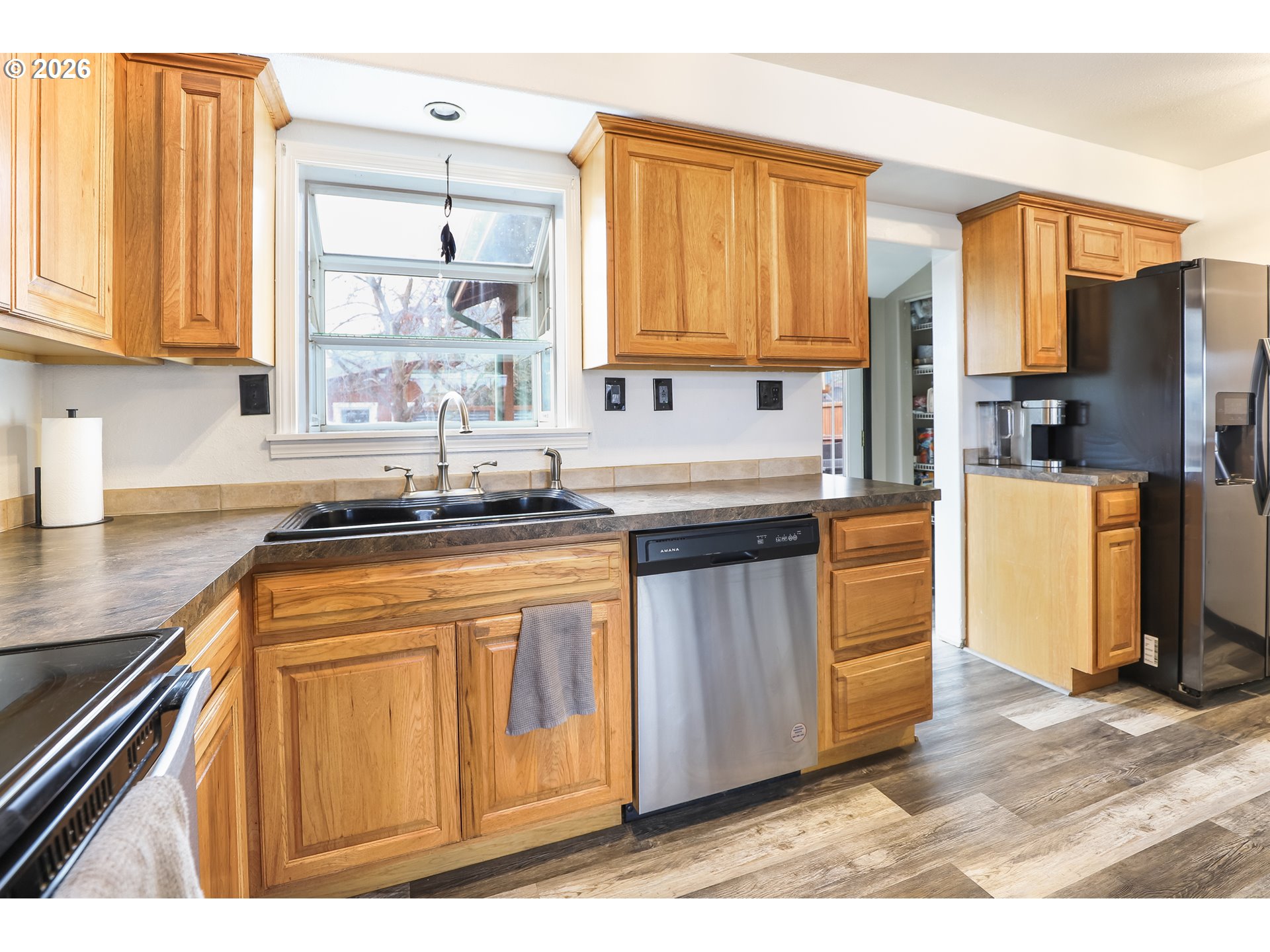 409 Northeast Court Street Dufur, OR 97021 - Photo 18 of 38 a kitchen with stainless steel appliances granite countertop a refrigerator a sink dishwasher and wooden cabinets