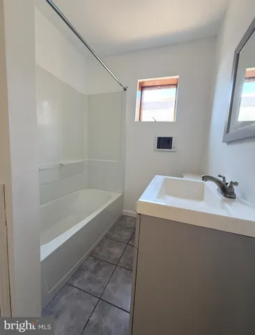 a bathroom with a tub sink and mirror