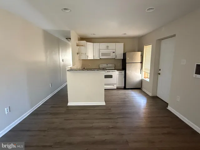 a kitchen with stainless steel appliances granite countertop a refrigerator and a stove top oven