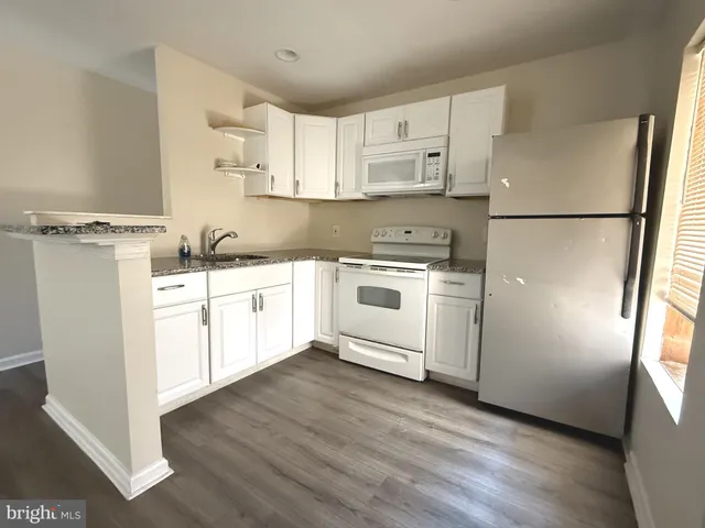 a kitchen with white cabinets and white appliances