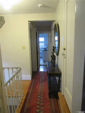 a view of a hallway with a livingroom and furniture