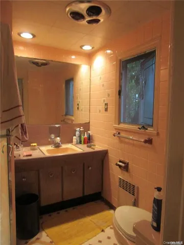 a bathroom with a toilet sink and mirror