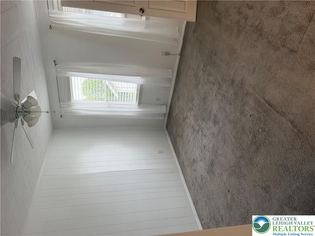 Soft carpeting pairs with paneled walls under a tiled ceiling.