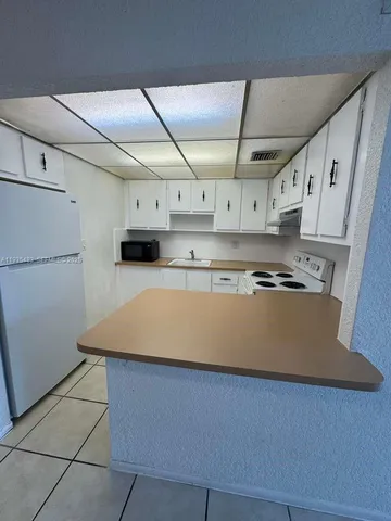 a view of kitchen cabinets and wooden floor