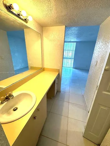 a bathroom with a tub a sink and a mirror