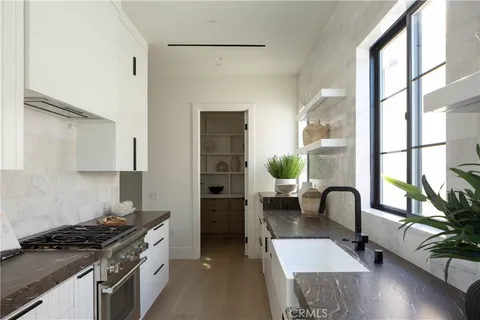 a kitchen with stainless steel appliances granite countertop a sink a stove and a wooden floor