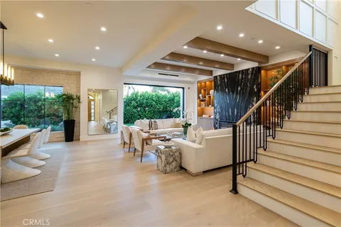 a living room with furniture kitchen view and a large window