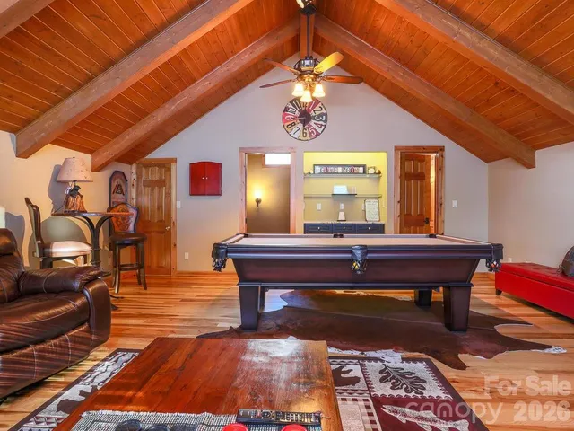 a room with furniture pool table and wooden floor