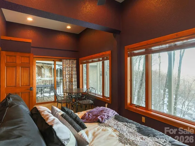 a bedroom with furniture and large windows