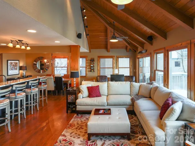 a living room with furniture a wooden floor and next to a window