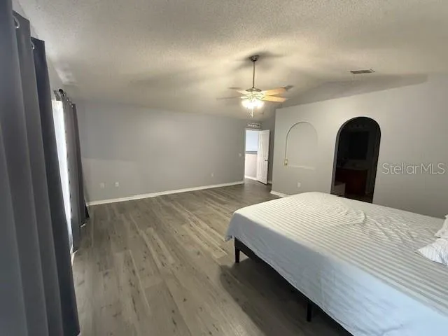 a bedroom with a bed and wooden floor