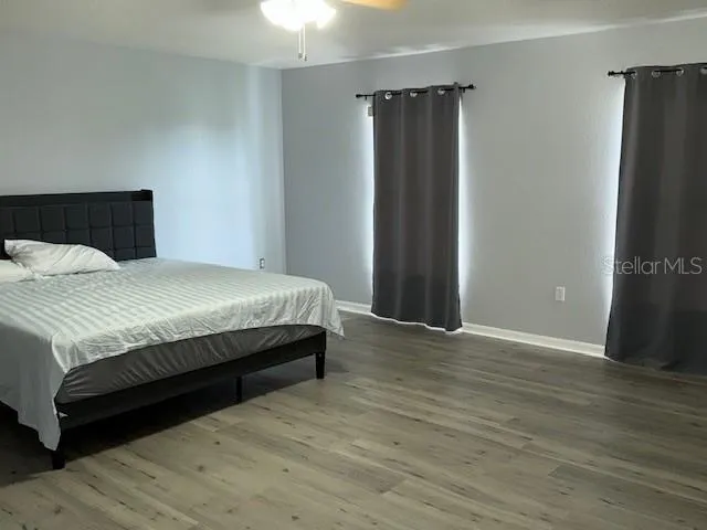 a spacious bedroom with a bed and a mirror