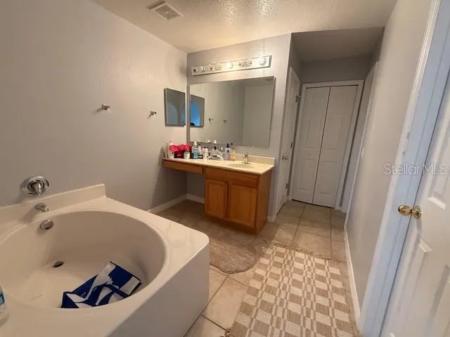 a bathroom with a tub sink and mirror