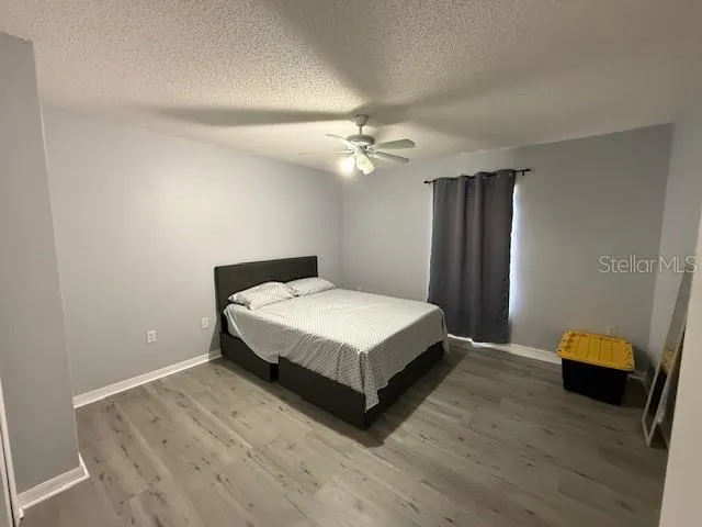 a spacious bedroom with a bed and a ceiling fan