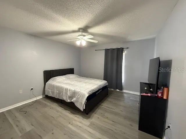 a bedroom with a bed and a flat tv screen on a dresser